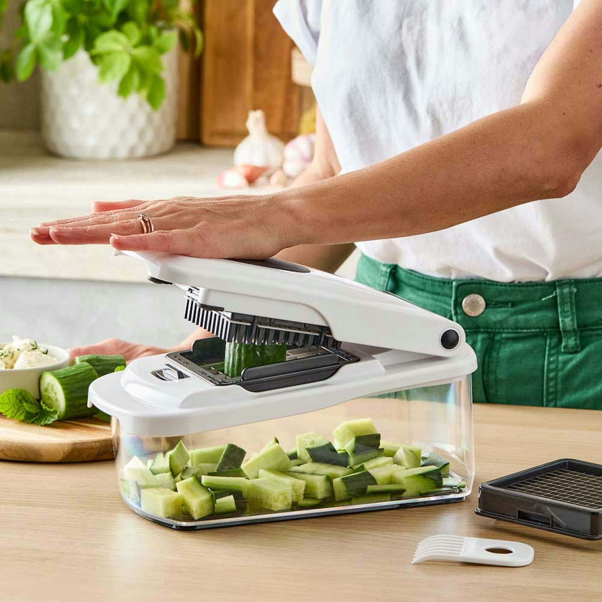 Woman using chopping food preparation tool.