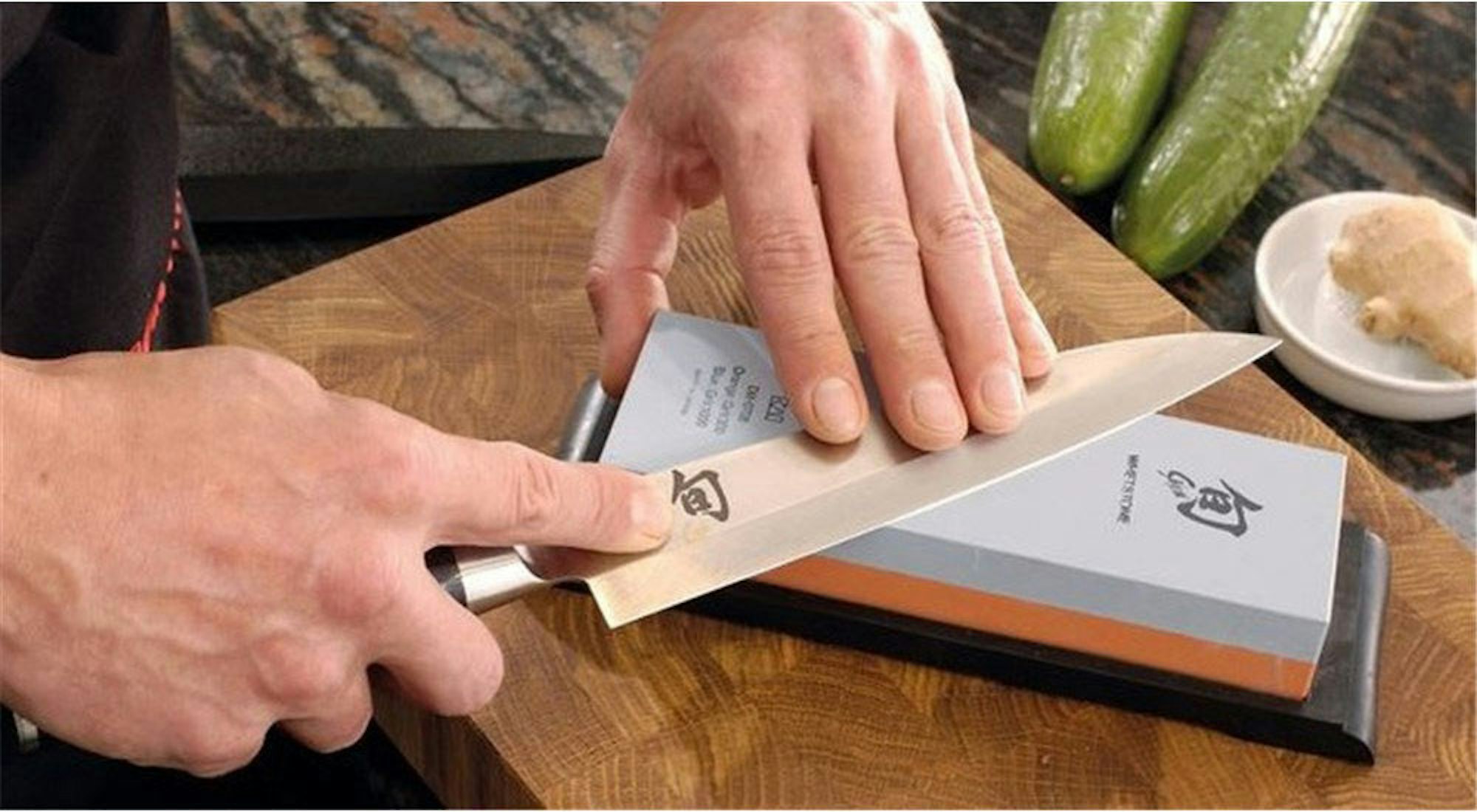 Man sharpening knife on whetstone - How to Sharpen a Knife House Blog