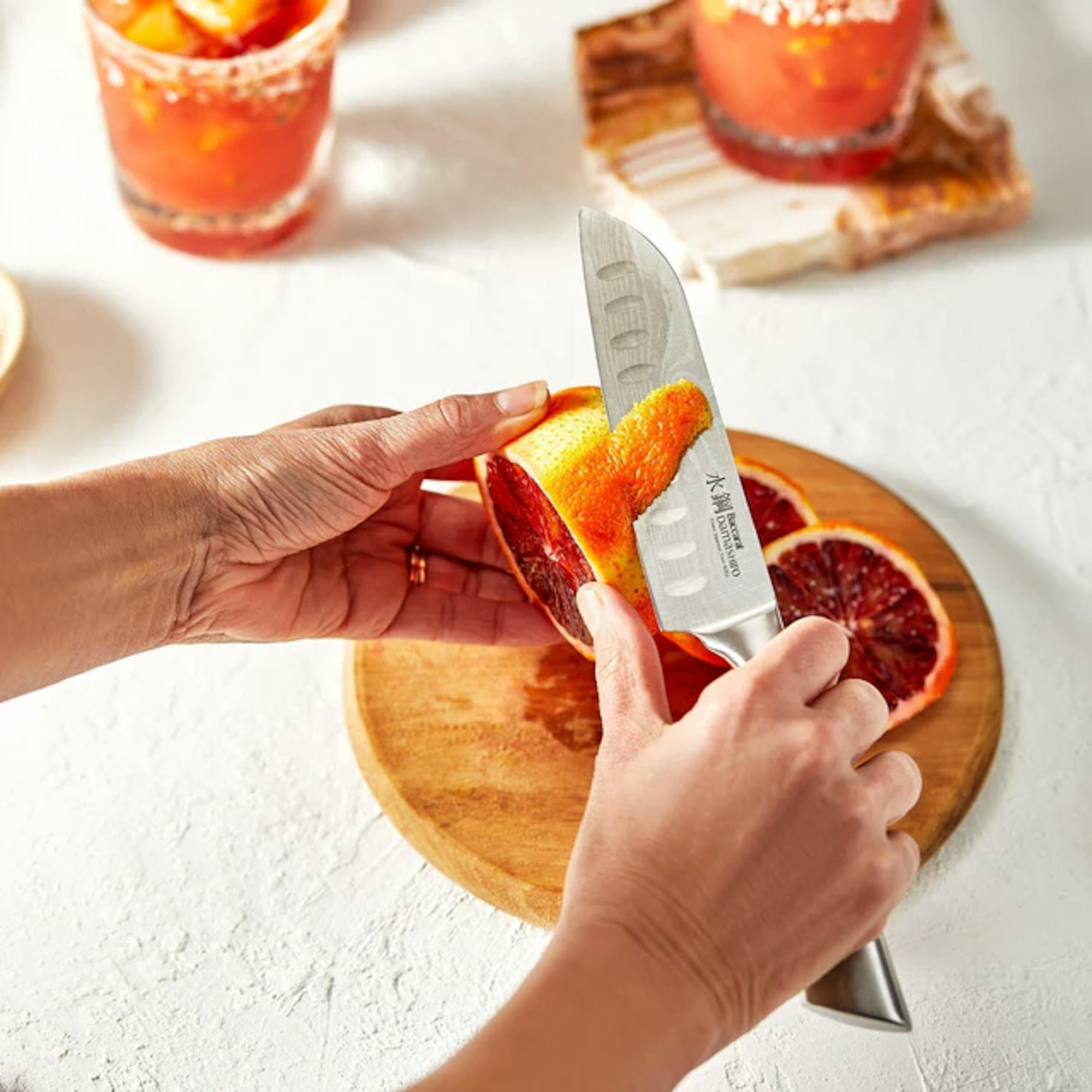 santoku knife being held to cut oranges