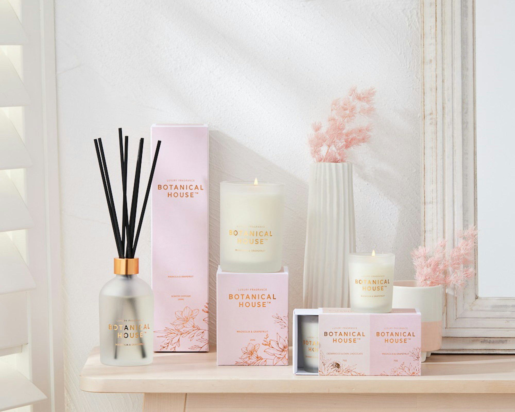 Stack of home fragrance. Scented candles, reed diffusers. Botanical House.