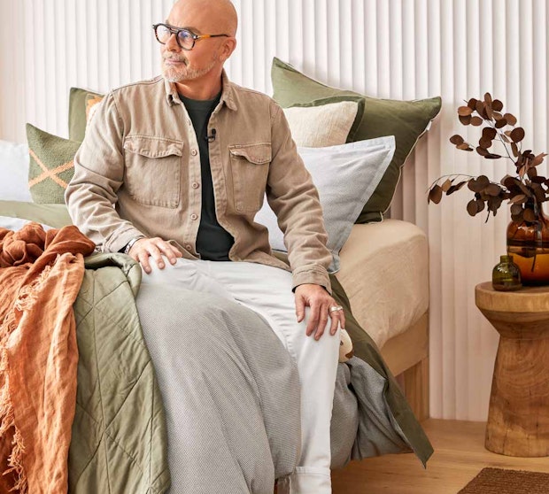 Neale Whitaker sitting on a bed