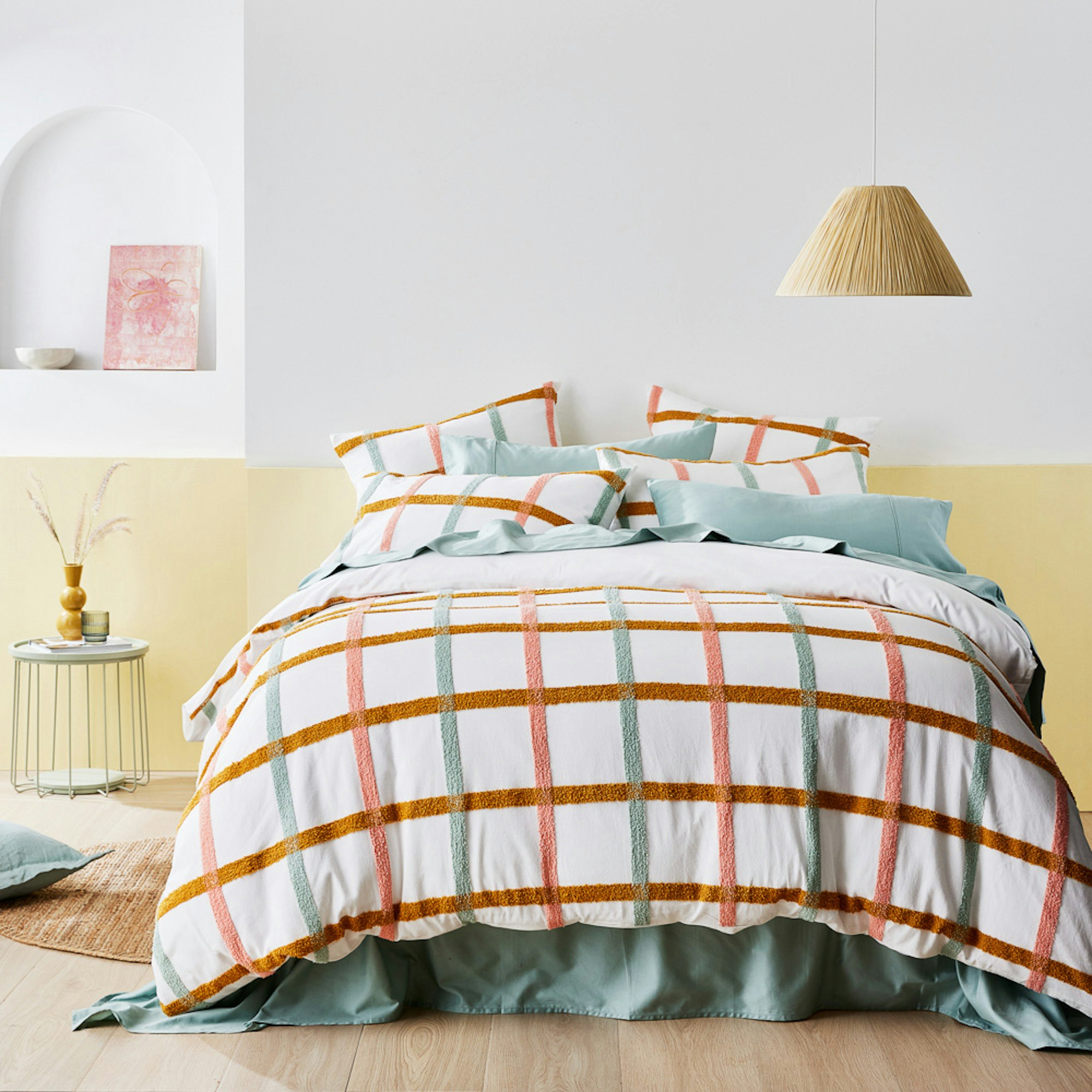 MyHouse SS23 collection. Full bedroom setting with White quilt cover with tufted check pattern in mint, pink, and gold.