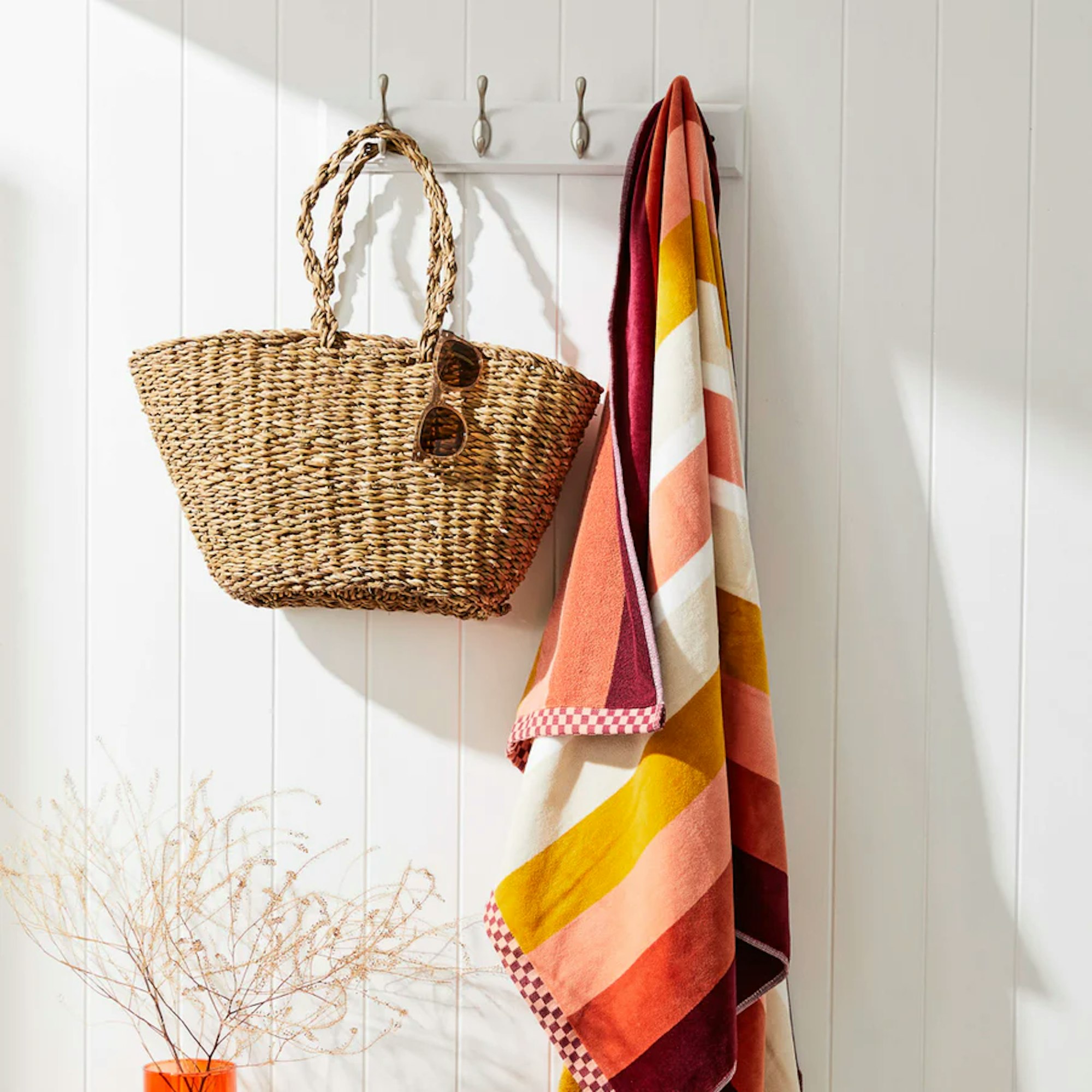 summer bag and blanket hanging from wall hook
