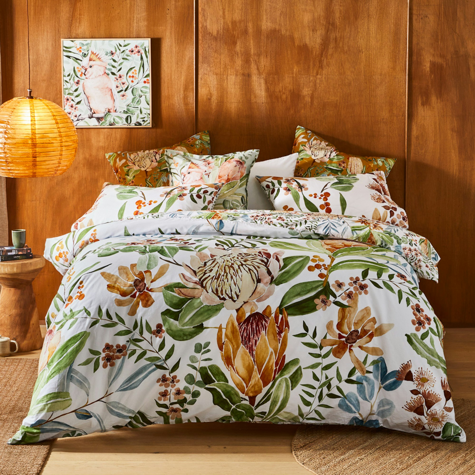 White quilt cover set with native Australian plant illustrations in front of a wooden wall