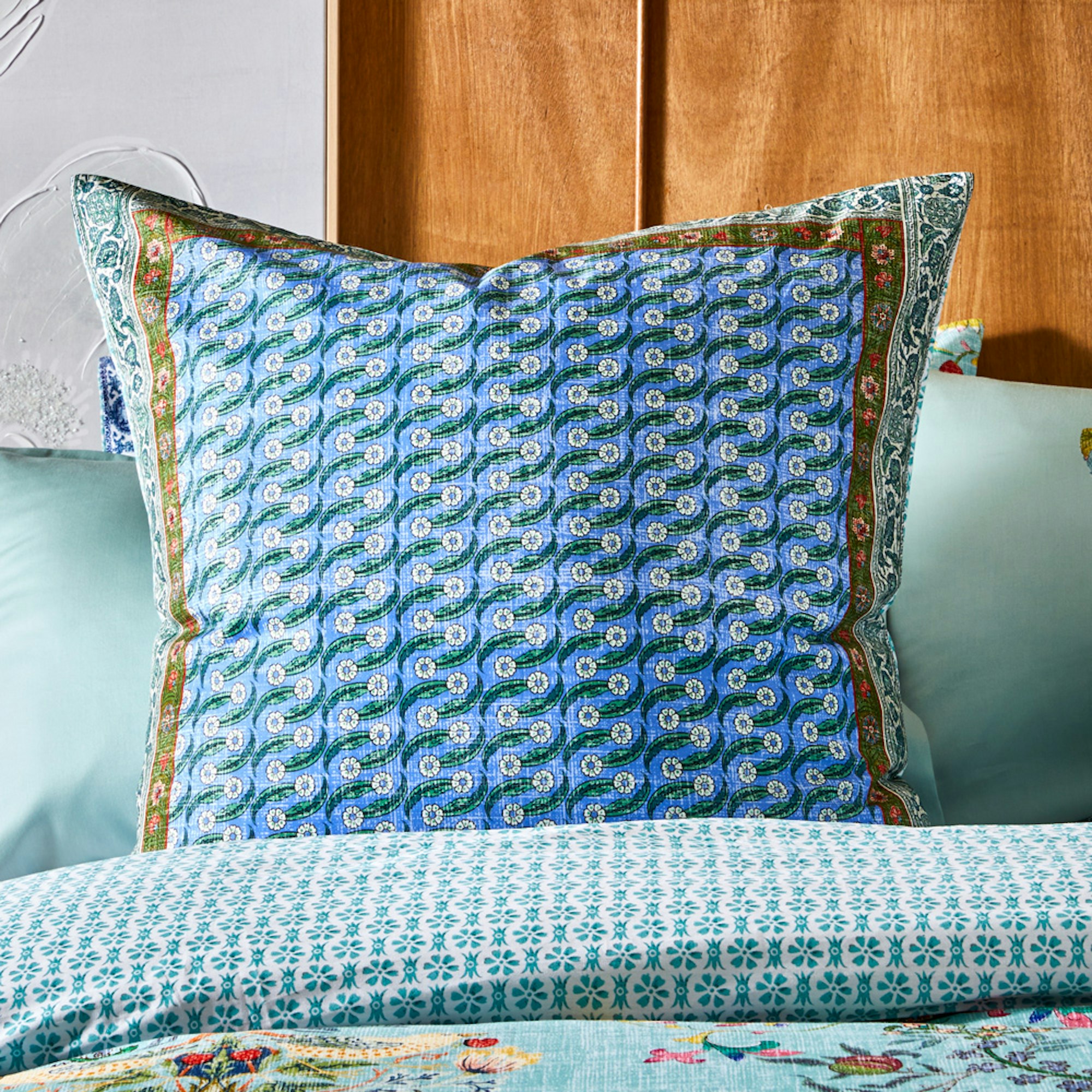 Blue European pillowcase on a bed - How to style your bed for better sleep blog