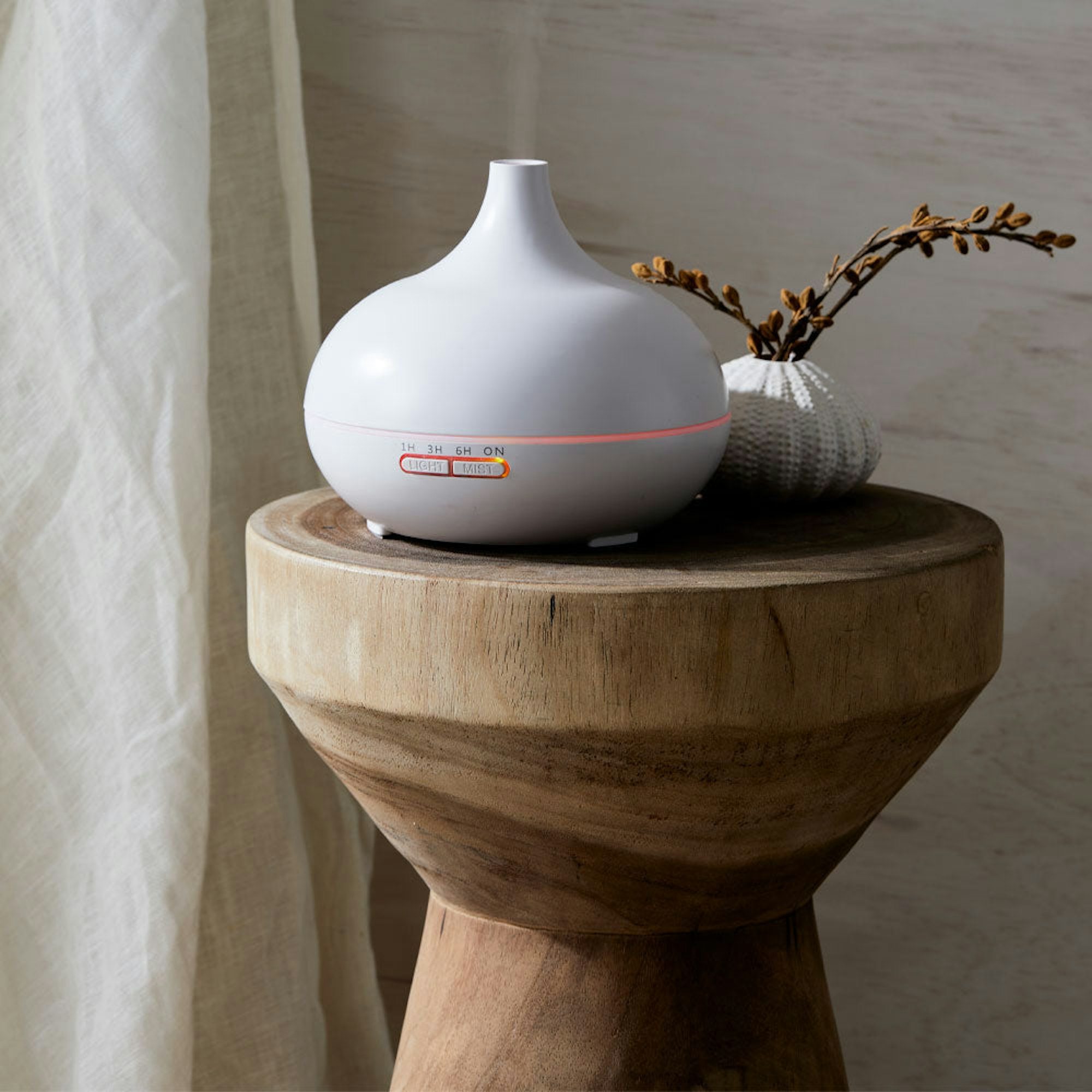 White diffuser on side table - How to style your bed for better sleep blog