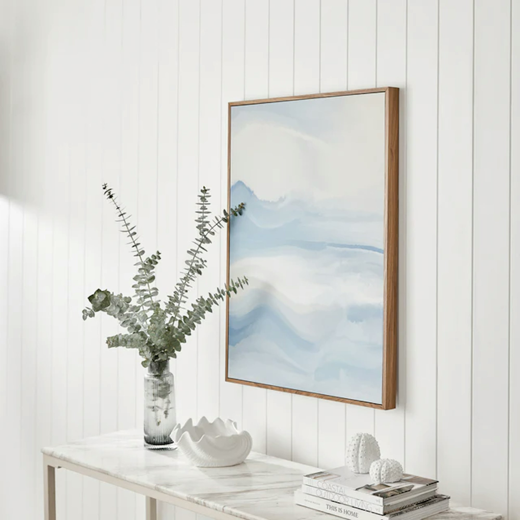 Coastal inspired picture hanging on a wall above a table