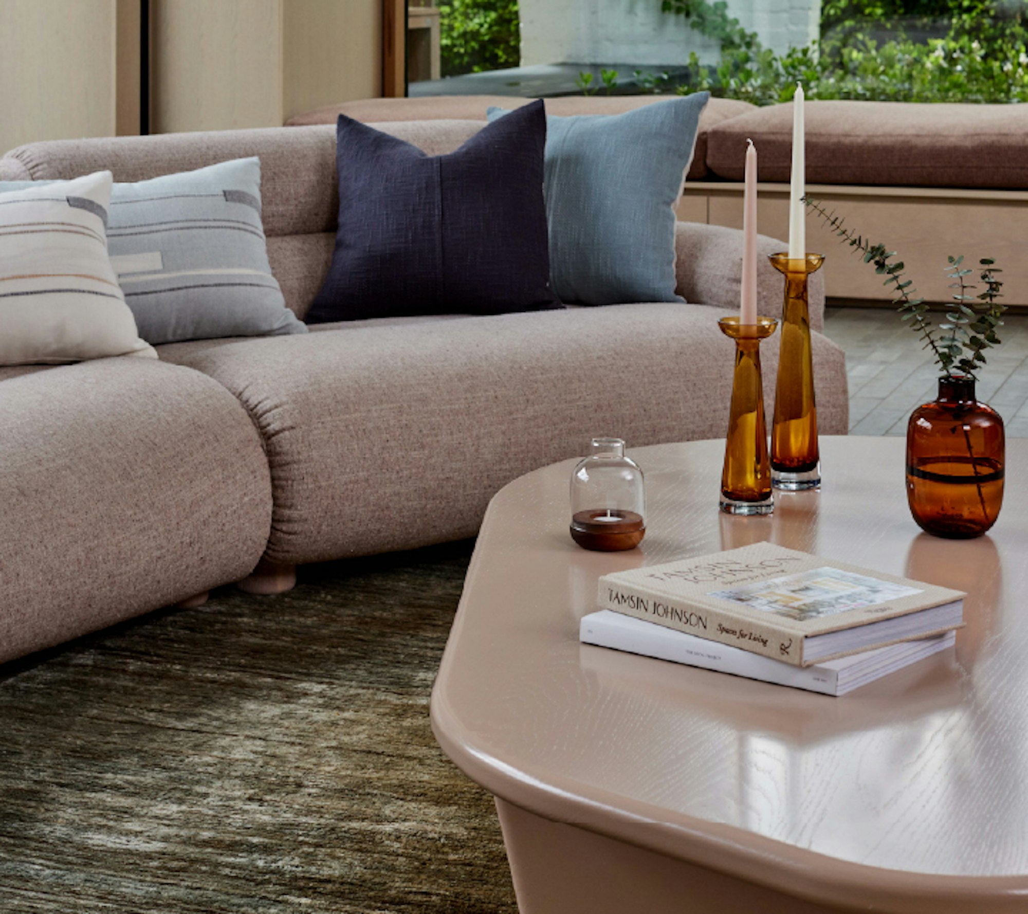 A couch placed in a living room on a rub with a coffee table in the same room