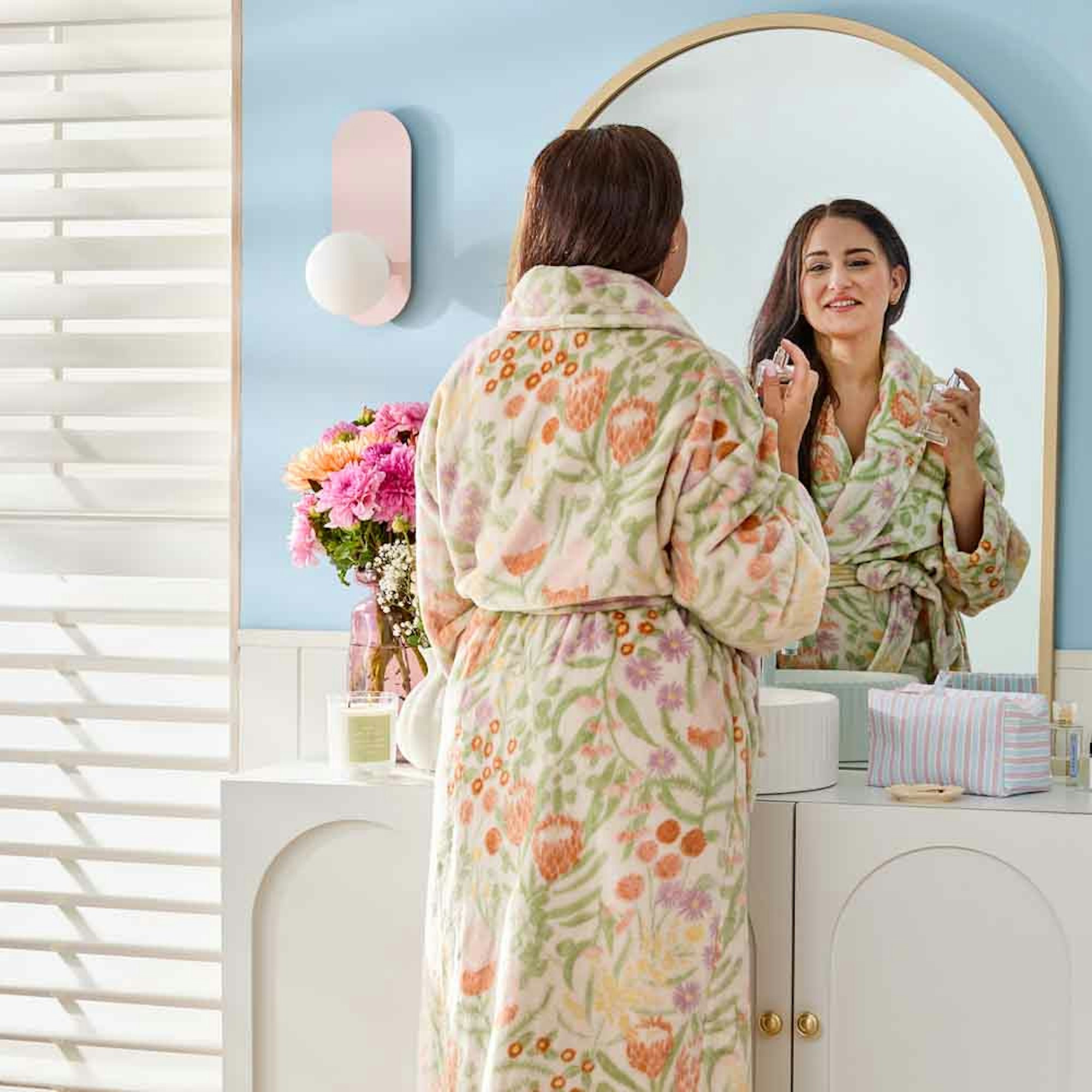 woman standing in front of a mirror in bathrobe - gift ideas for her