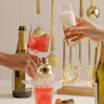 champgane bottle and glasses with people holding them