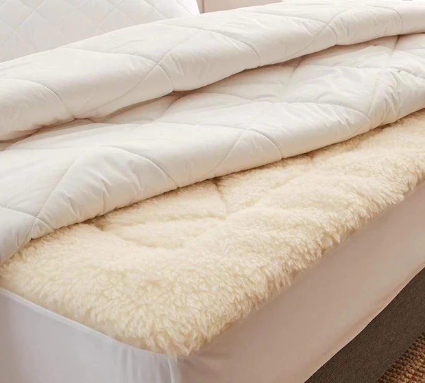 MyHouse Luxe Wool 300 Quilt folded back on a bed, featuring a quilted cotton cover layered over a plush wool underlay in a neutral bedroom setting