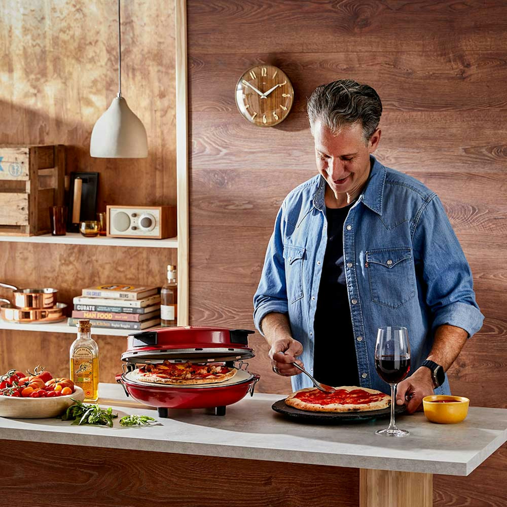 Guide to Secret Santa Gift Ideas. Pizza making tools. Man in the kitchen preparing pizza with pizza maker.