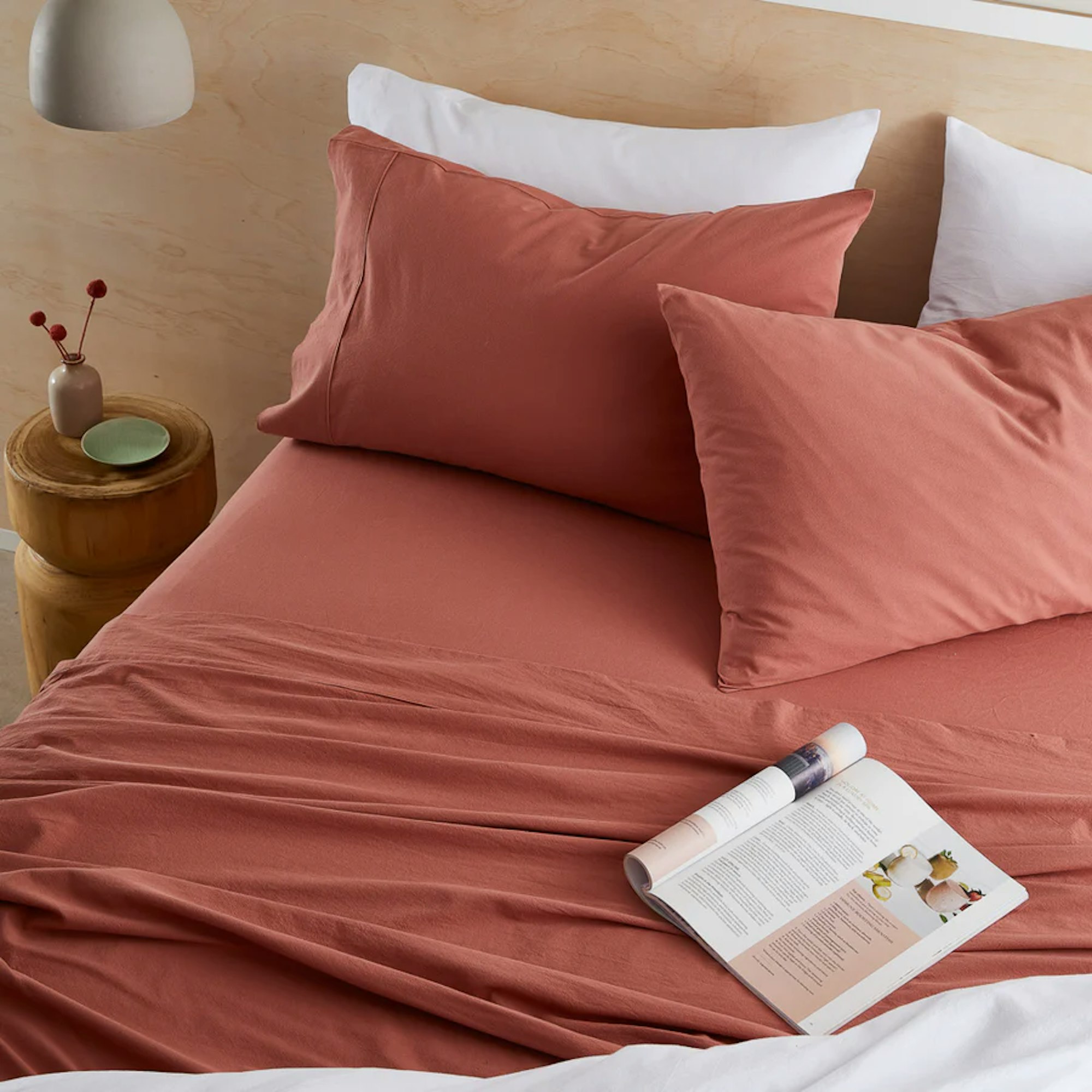bamboo cotton material bed sheets on bed with book and matching pillows