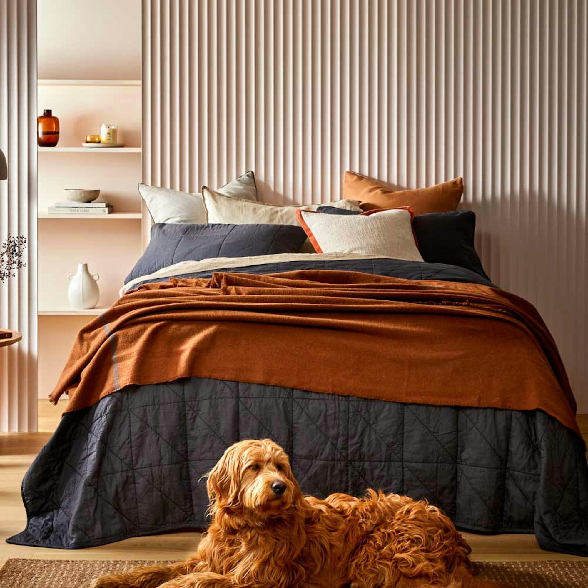 Neale Whitaker AW24 collection bed linen and decor. Dog lying down in front of a bed.