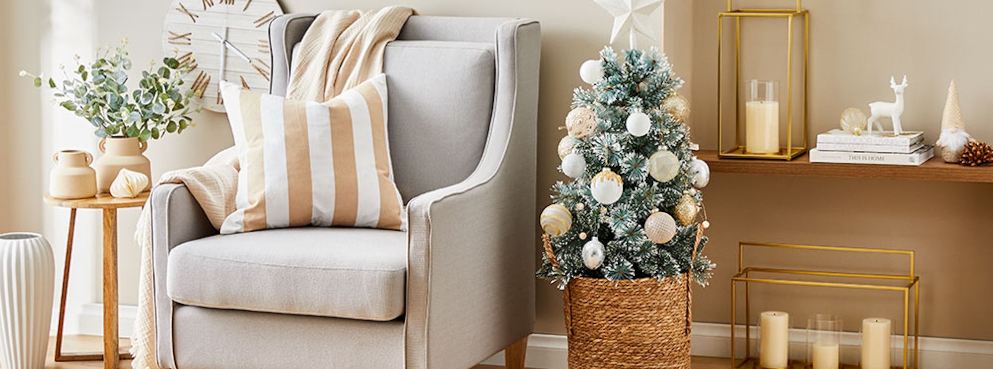 Light filled room with armchair, Christmas decor and Christmas tree.