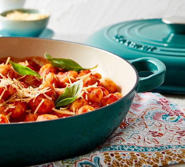 Baccarat Le Connoisseur Dutch Ovens and Baking Trays. Dutch Oven with pasta dish resting on a multicoloured teatowel.