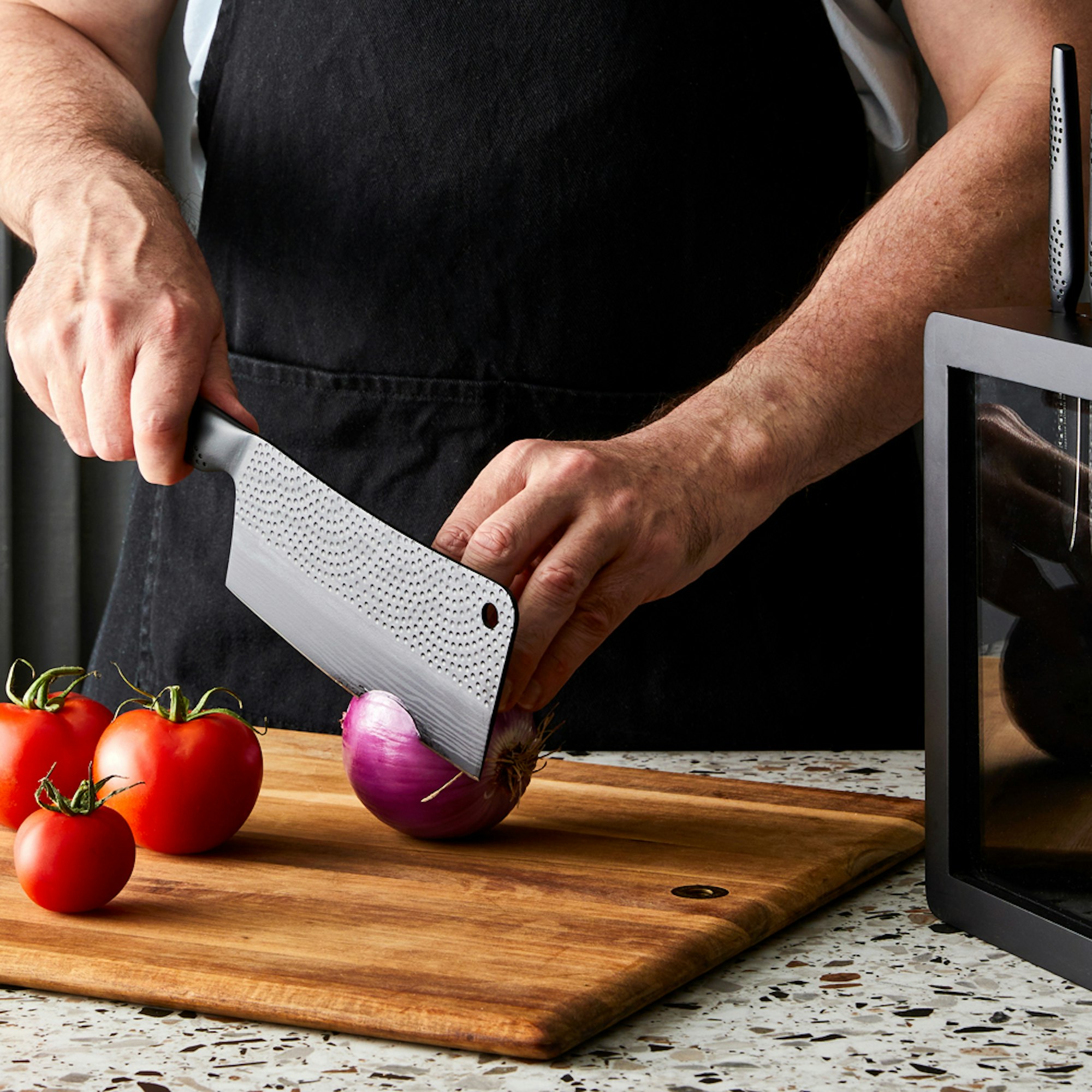 man with cleaver chopping an onion