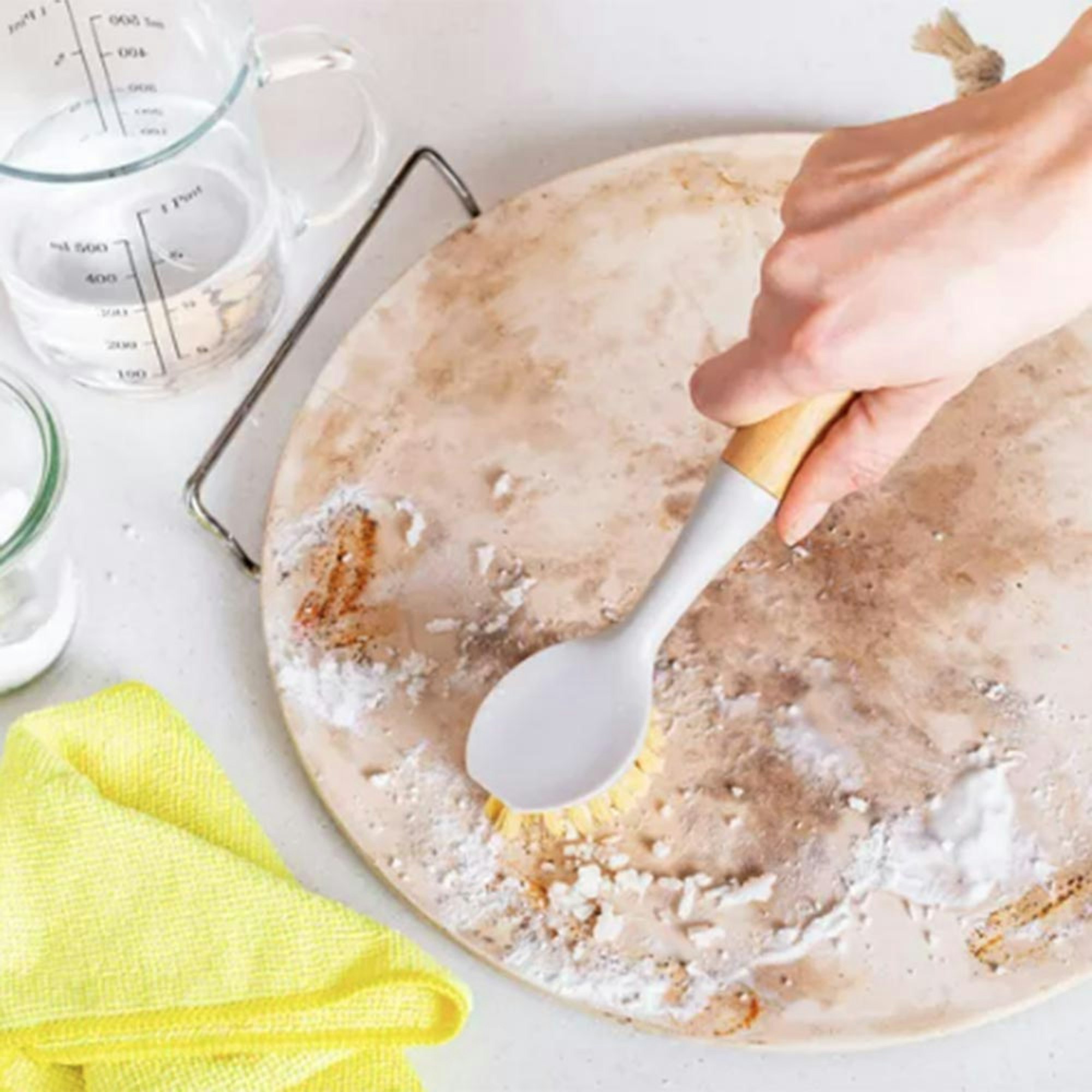 How to clean a pizza stone? person scrubbing pizza stone