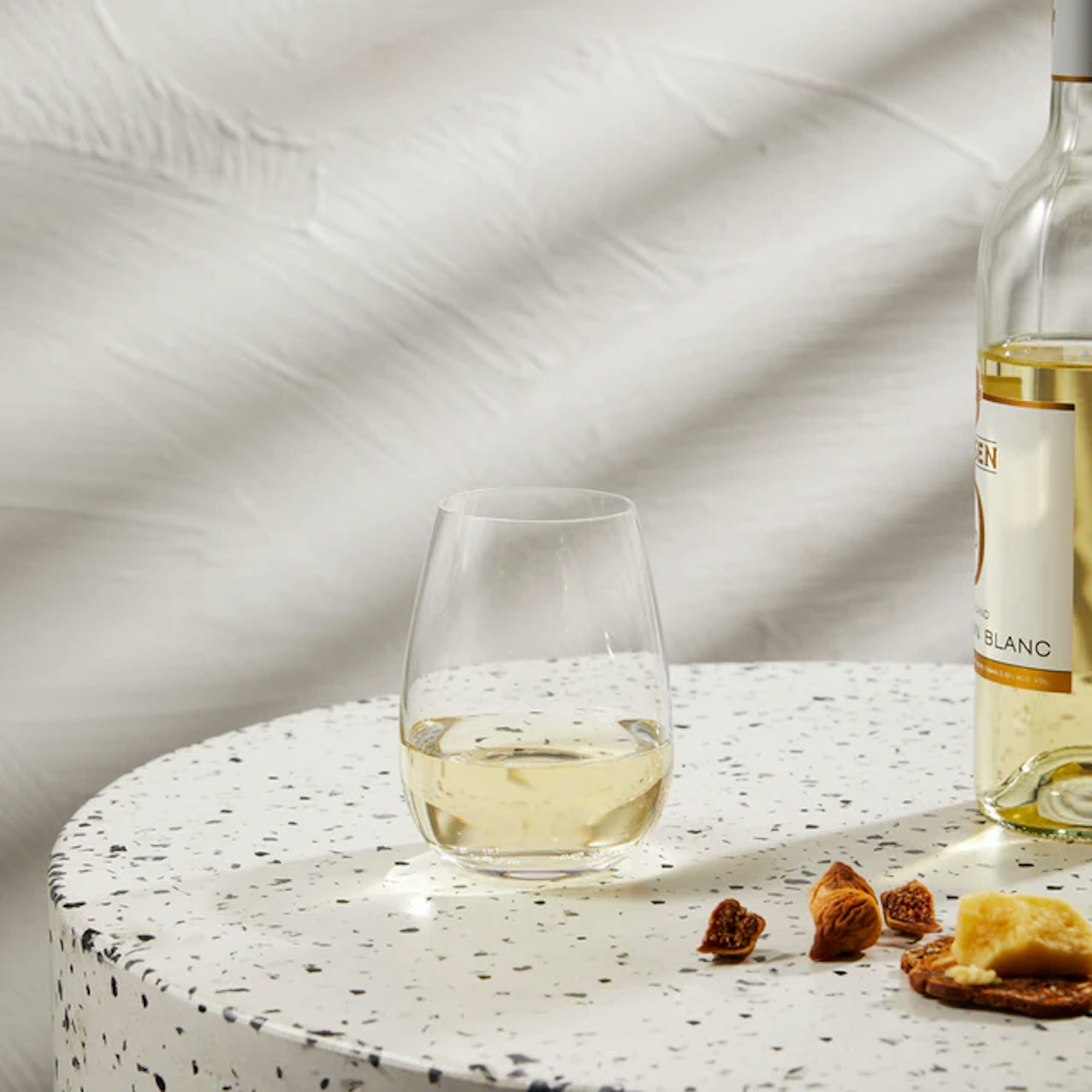 Modern wine glass with white wine placed on a round bench
