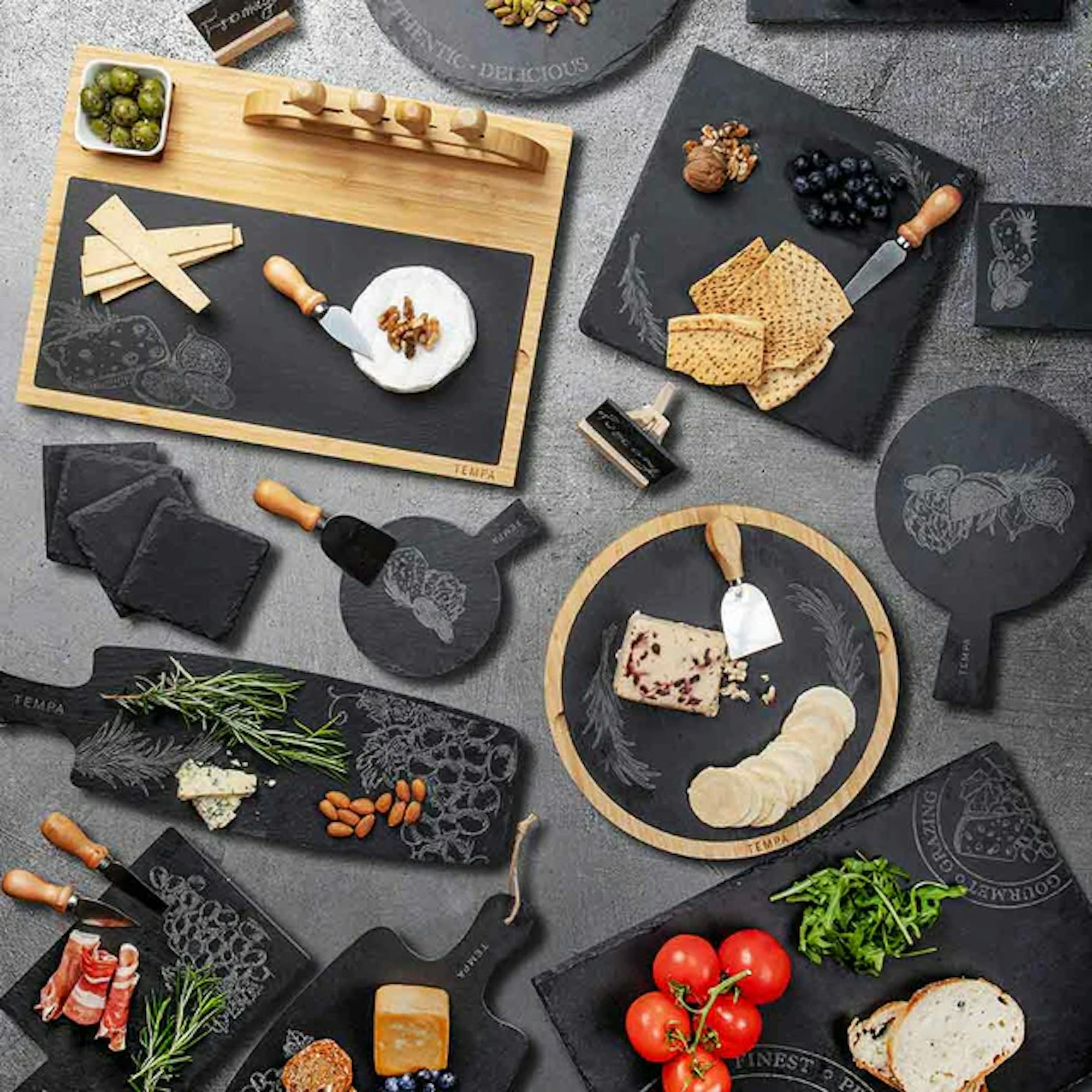 A set of different serving board with cheese, cured meats, vegetables and specialty serving utensils