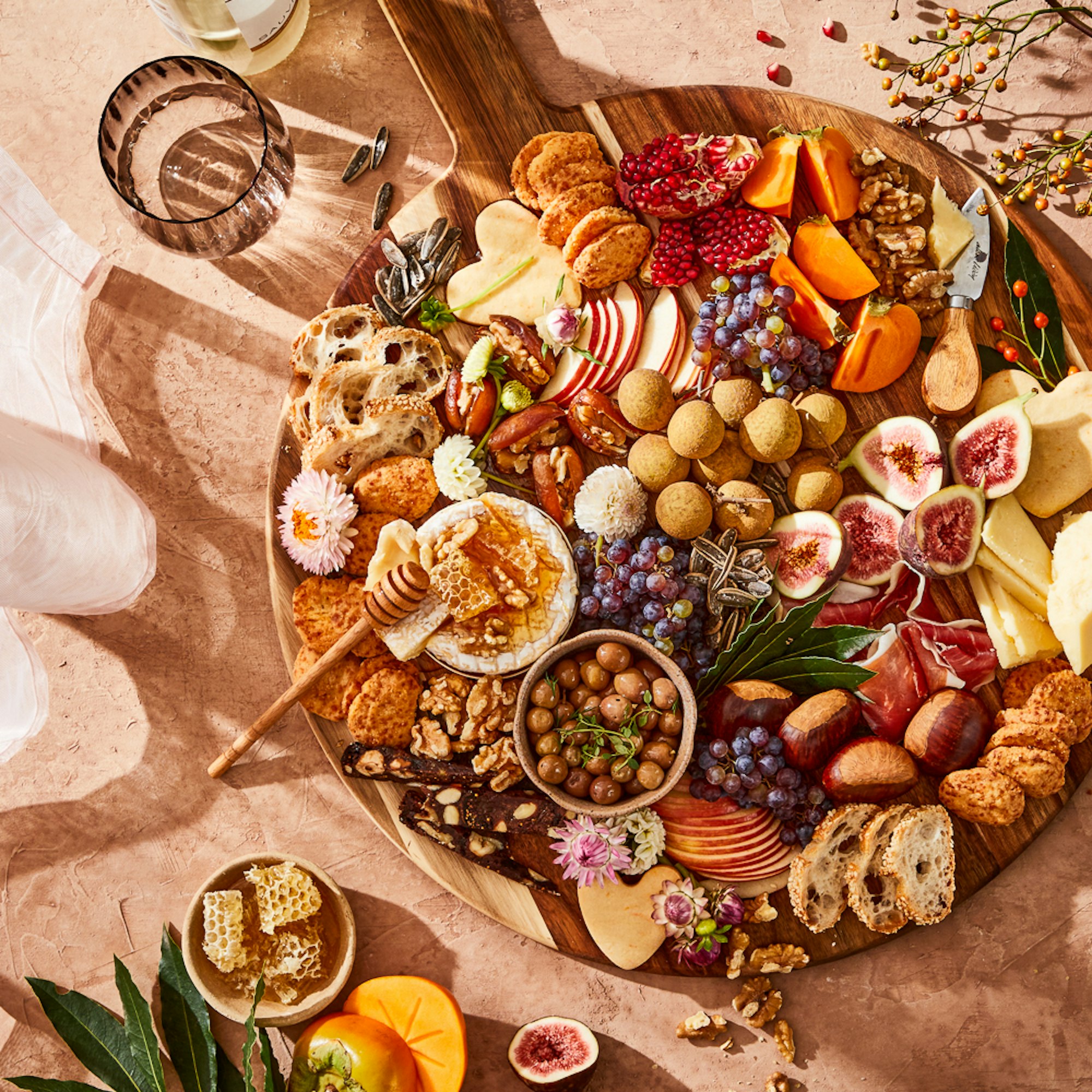round grazing serving platter board filled with charcuterrie cheese, fruit and meat.