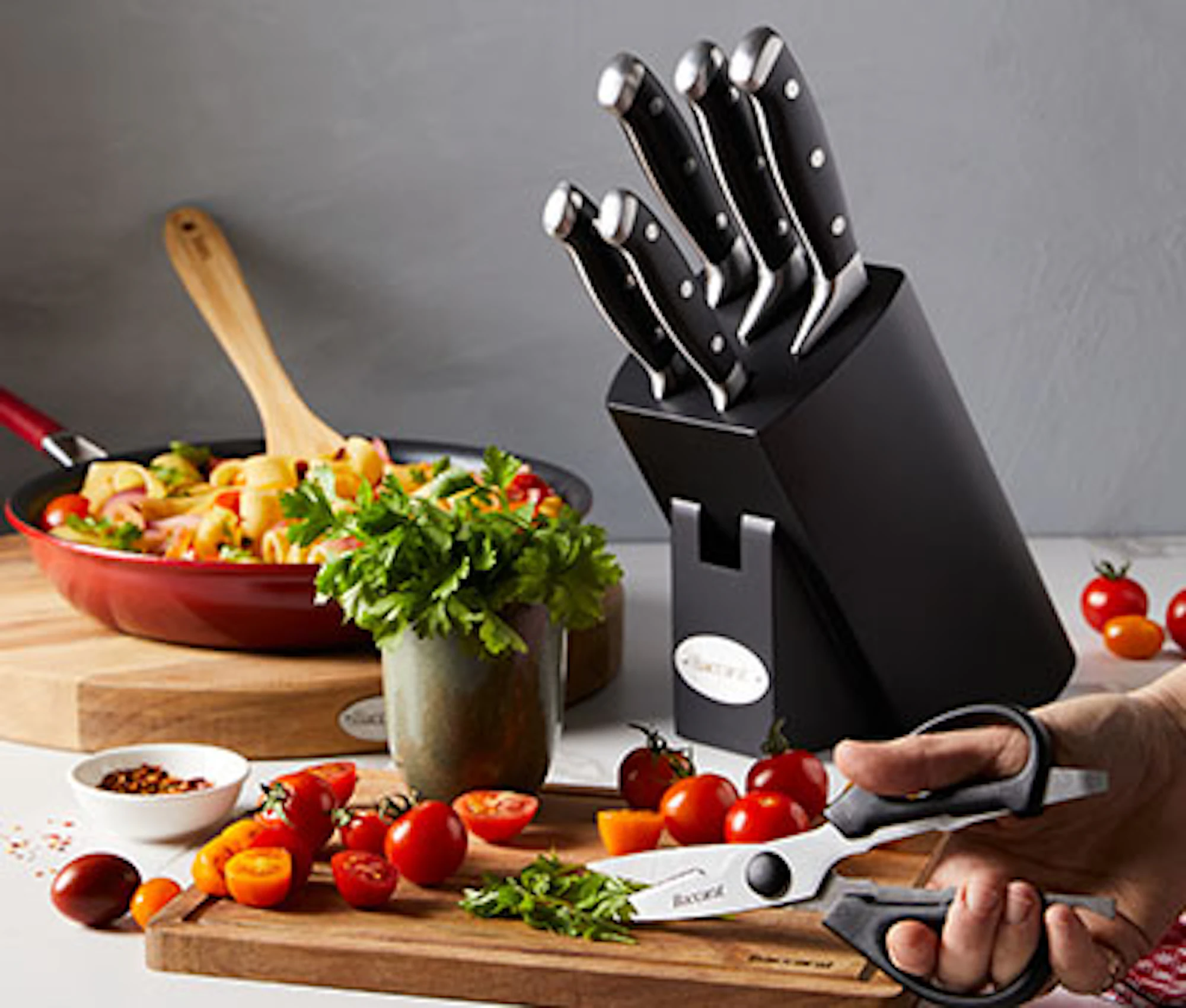 Robins Kitchen knife block set with stainless steel kitchen knives, displayed alongside chopped vegetables on a countertop