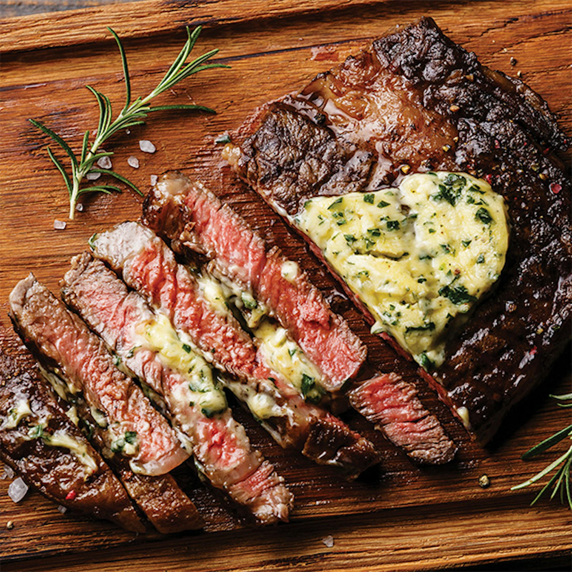 steak with herb butter on wooden board. How to reverse sear a steak