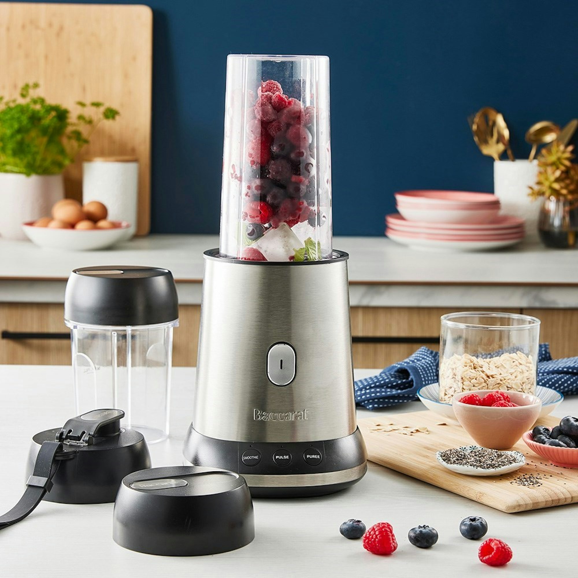 Blender filled with berries sitting on kitchen counter 