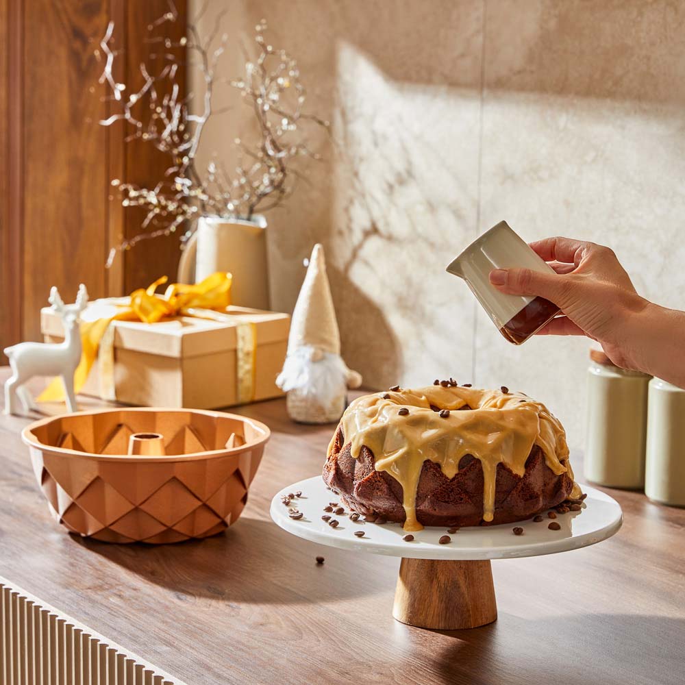 Soffritto Bakeware. Bundt cake with icing on a cake stand with pandora bundt cake tin. 