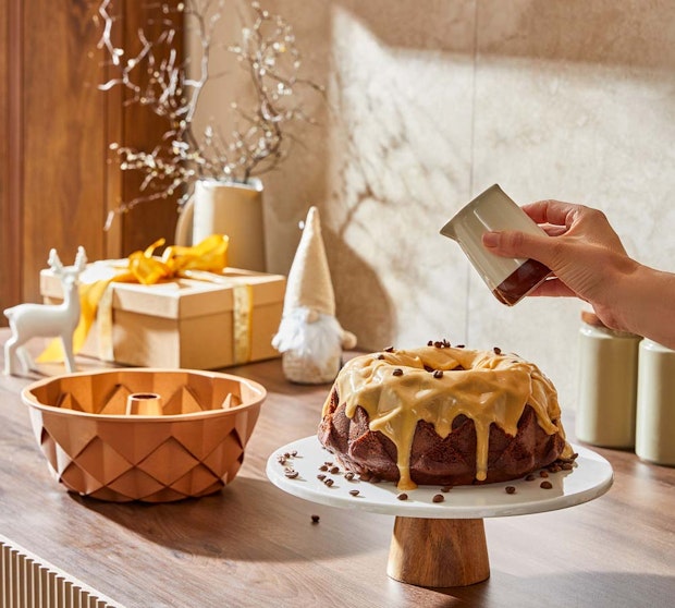 Soffritto Bakeware. Bundt cake with icing on a cake stand with pandora bundt cake tin.