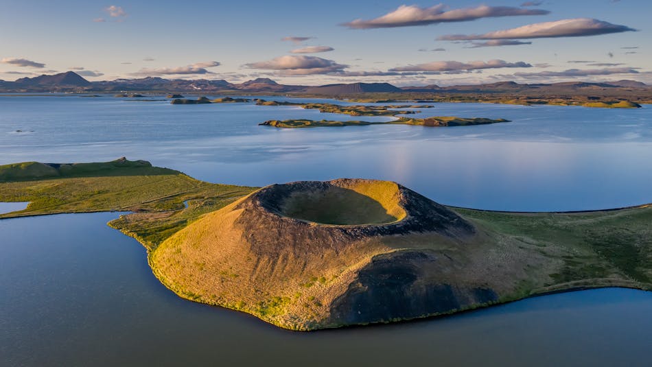 A volcanic crater in North Iceland with a lake and mountains in the background. Peaceful nature in Iceland.