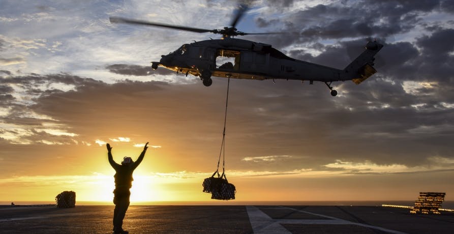 helicopter landing cargo in sunset