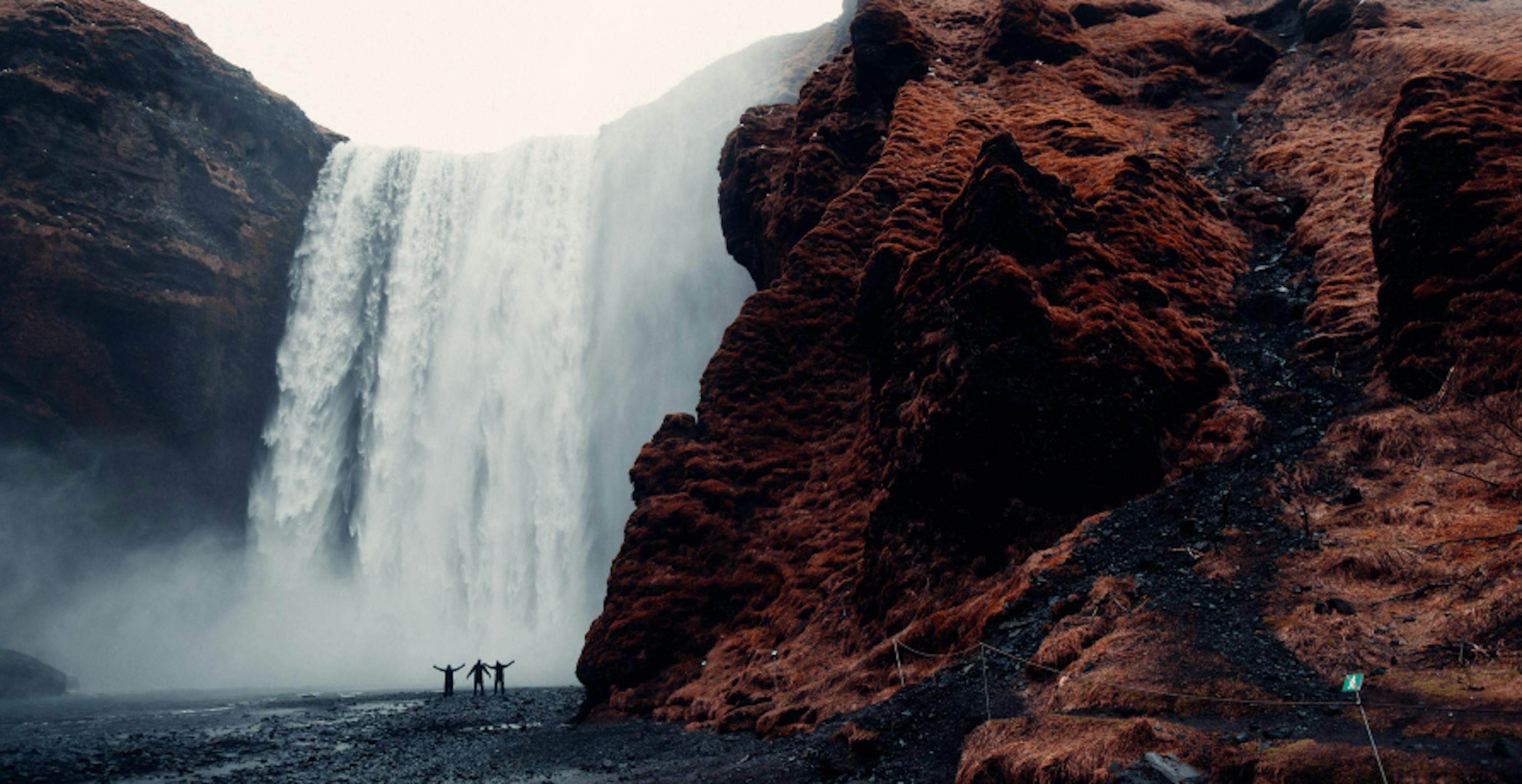 Waterfall with people standing in front of it