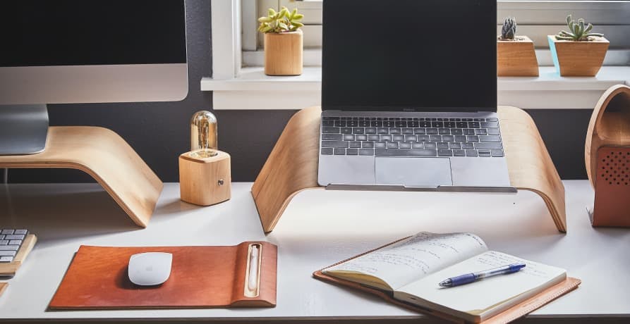 desk with computer screen and laptop on it