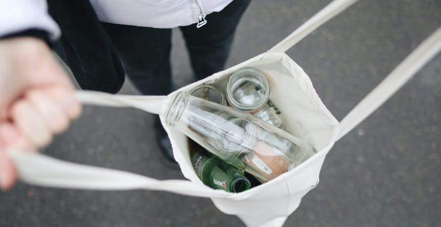 person holding their recycling in a bag