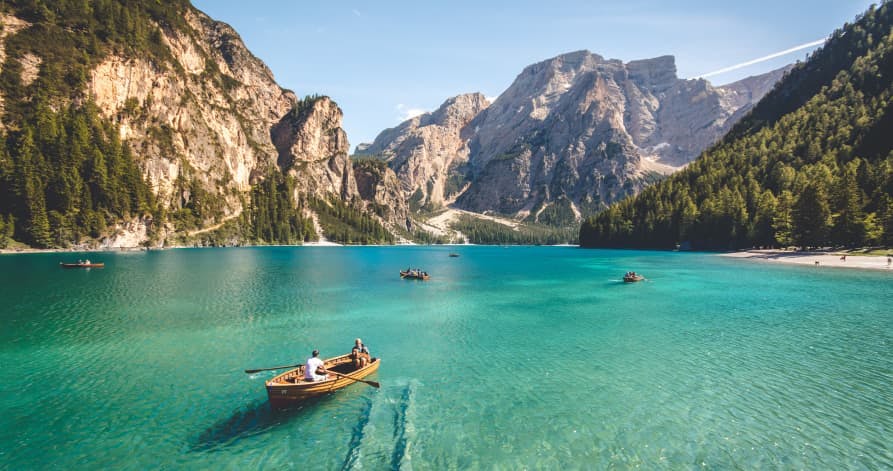 people in teal lake on canoe