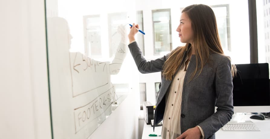 woman writing on white board