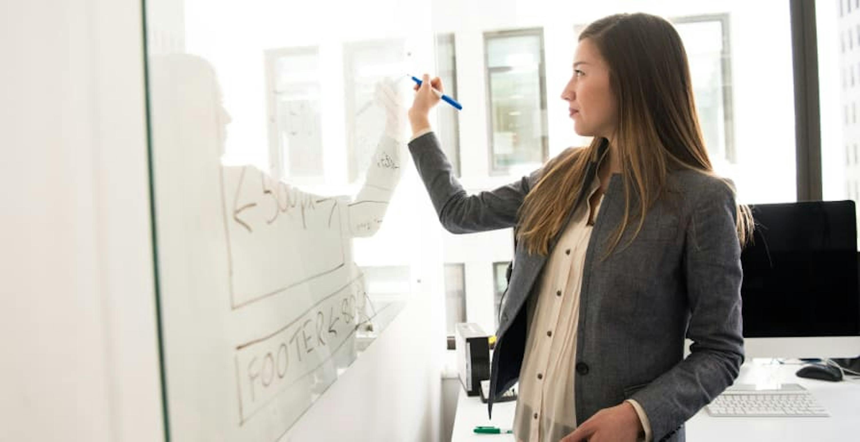 woman in an office drawing on a whiteboard