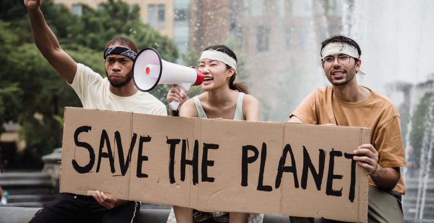 trois manifestants tenant une banderole indiquant "save the planet"