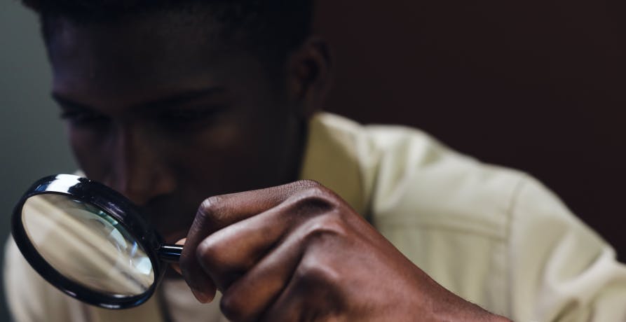 un homme regardant à travers une loupe