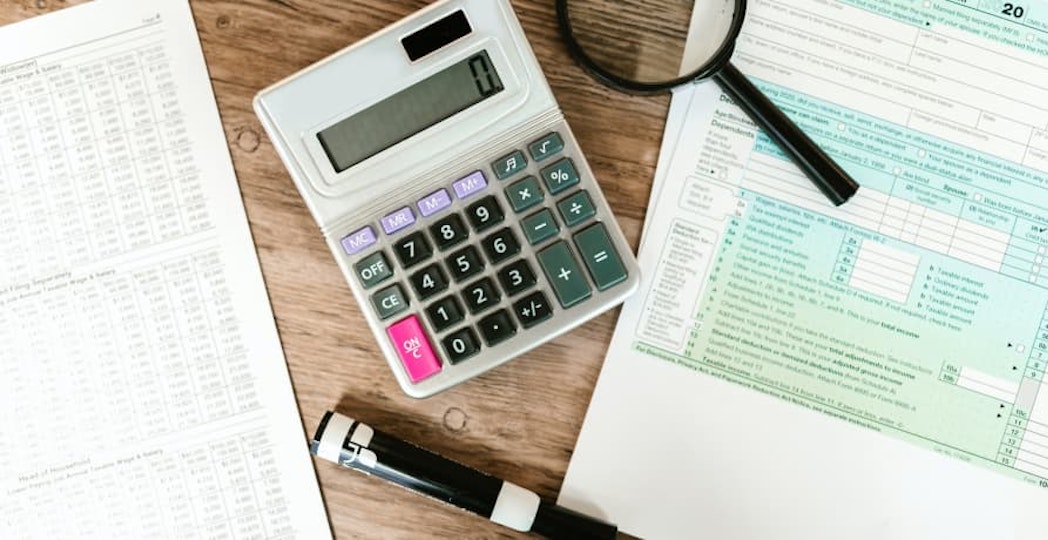 calculator, magnifying glass, paperwork