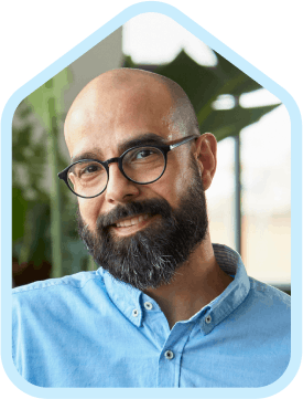 man smiling with blue shirt beard glasses 