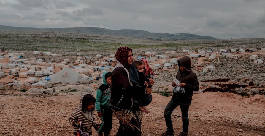 refugees walking across barren land