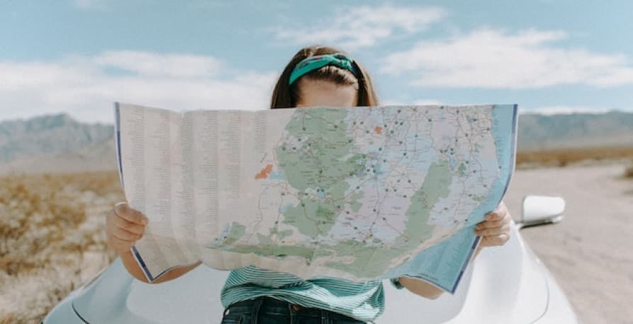 person holding map on a road trip