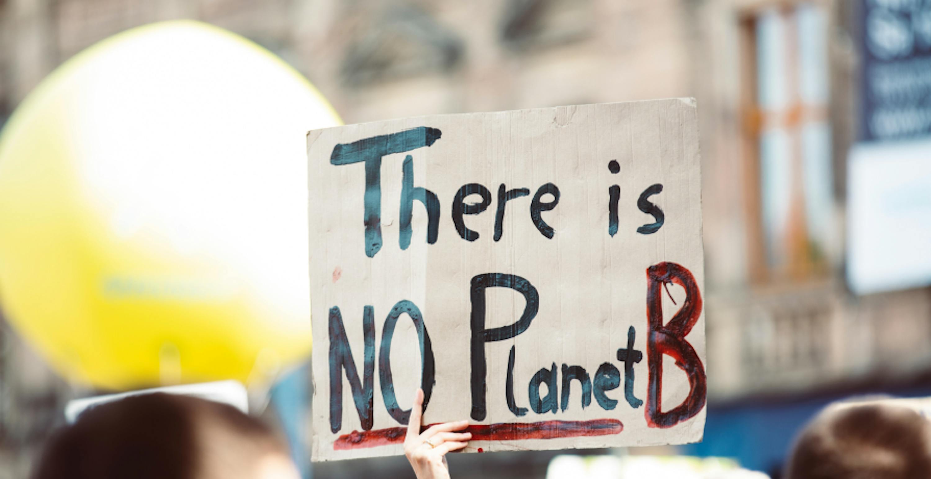 environmental protestor holding up sign