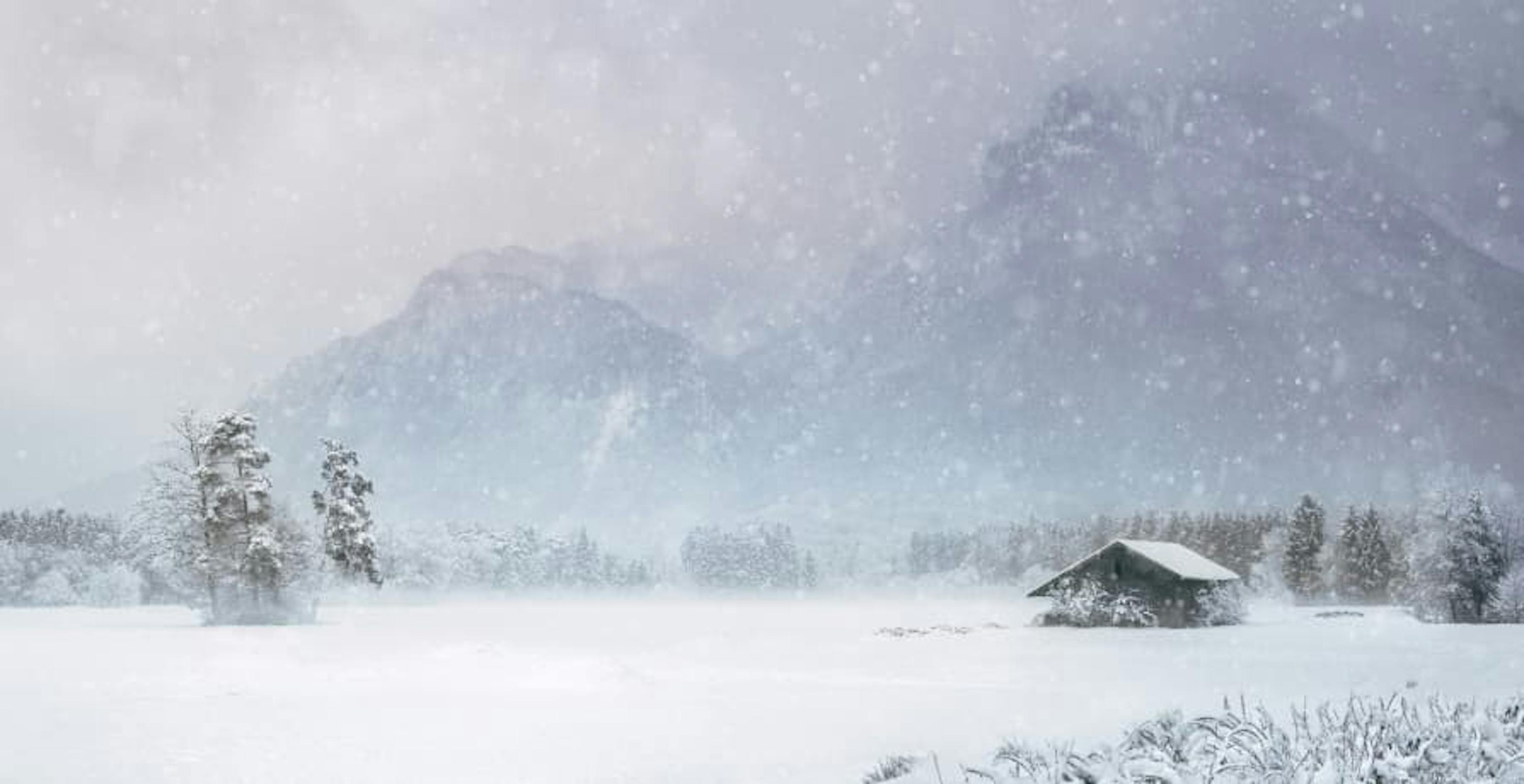 snow falling in small village near mountains