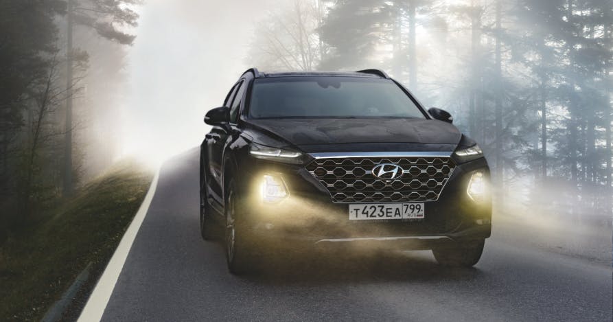 black suv driving on street with headlights