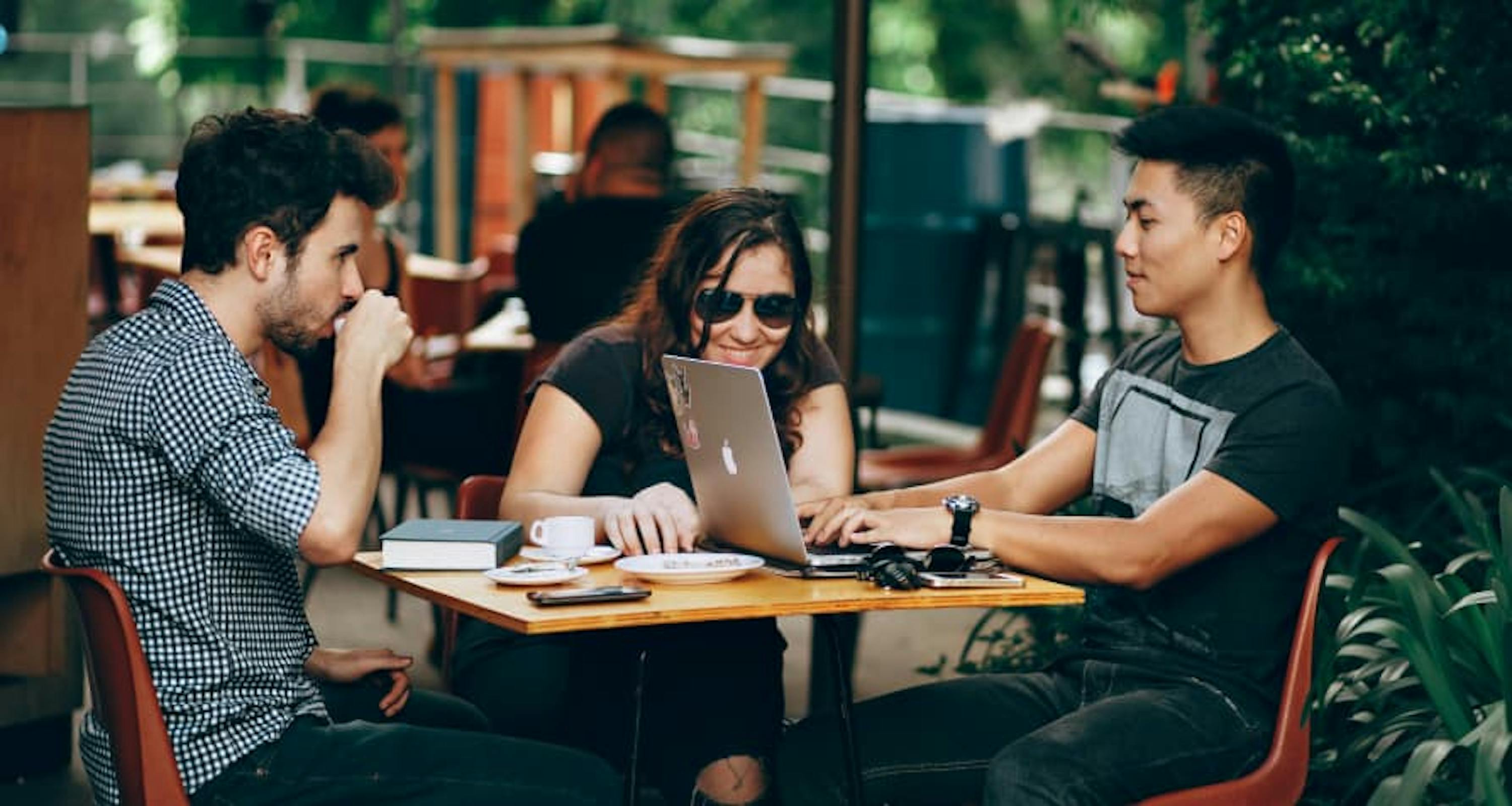 millenials crowidng around at desk remote working