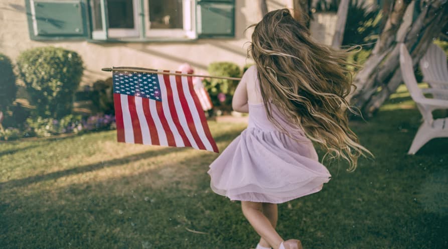 little girl long hair twirling american flag