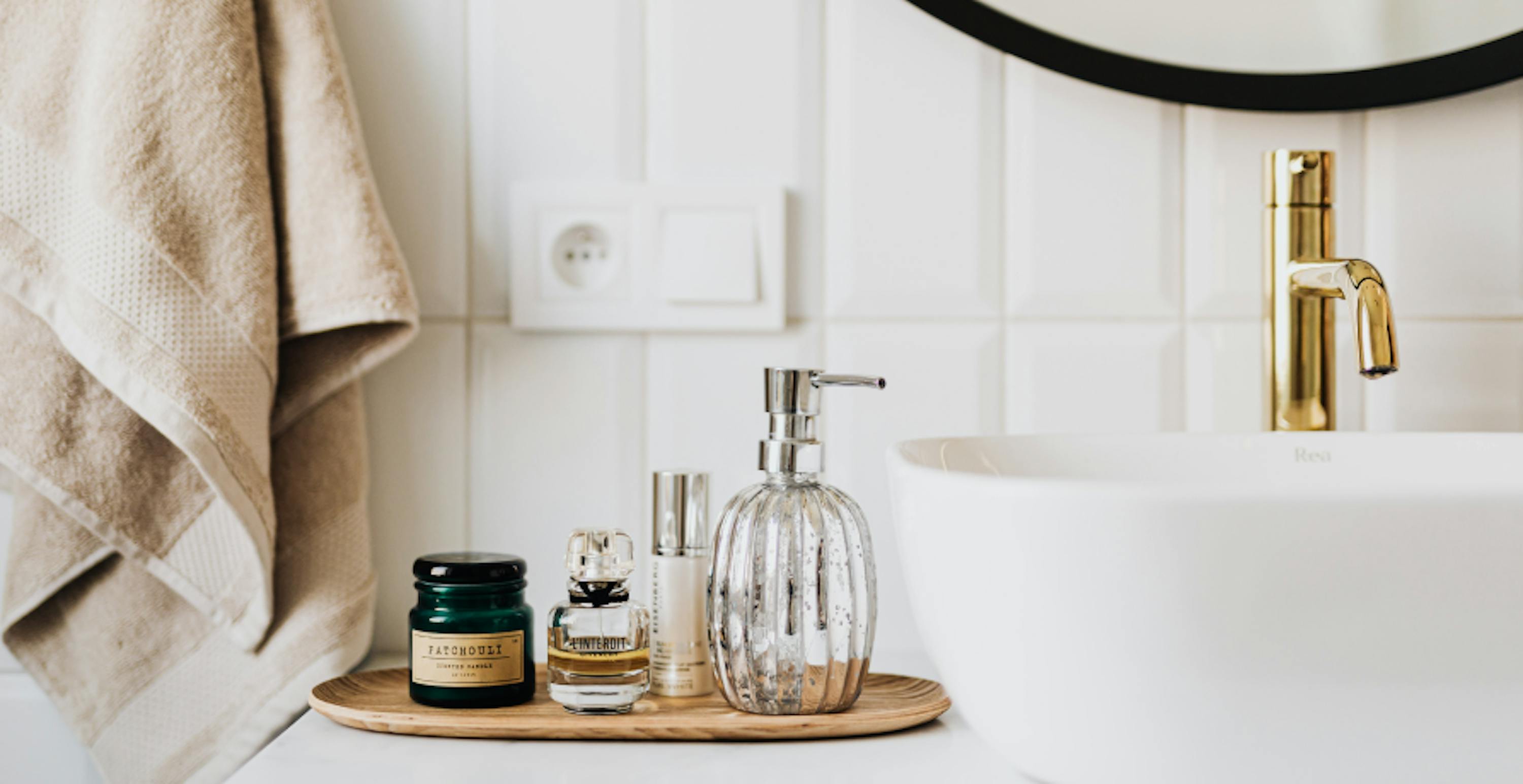 des produits de beauté disposés à côté d'un lavabo dans une salle de bain